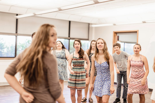 Dance instructor looking over her shoulder in high school student dance class