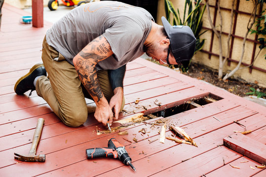 Man repairing wooden decking