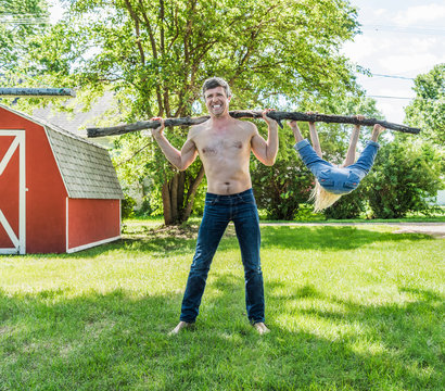 Father lifting son on stick