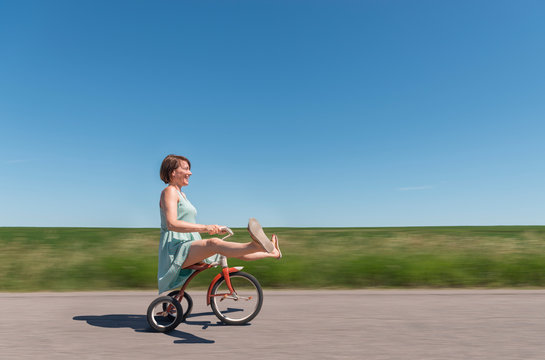 Side view of woman riding tricycle in rural area