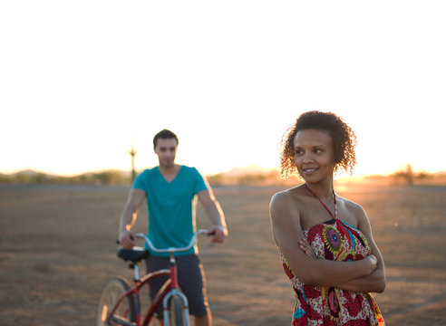 Young couple standing in desert at sunset