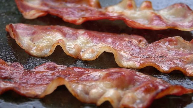 Close-up of a slice of bacon fried on grill