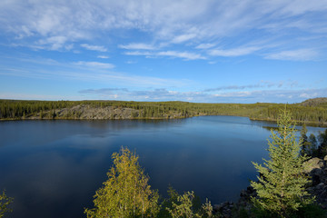 Fototapeta na wymiar Blue Lake - Crystal blue lake surrounded by thick boreal forest. Yellowknife, NWT, Canada.