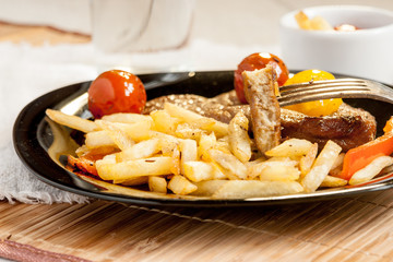 Vegetarian steak from vegan meat seitan, cherry tomatoes and fries