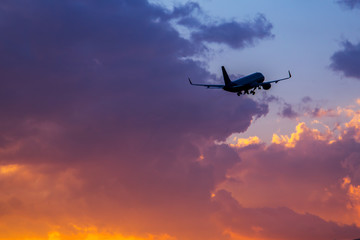 Passenger airplane flying in the sky at sunset