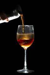 Hand pouring soft drink from can into glass.Bartender serving customer a cold fizzy cola soda with no ice ,isolated black background
