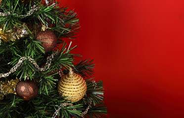 Beautiful Christmas green tree with ball on the branches on red