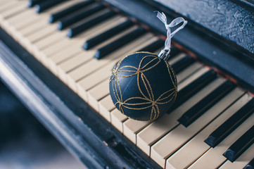 Blue Christmas ball on a piano keyboard