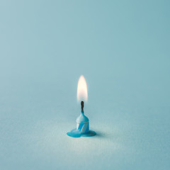 Burnt out candle on blue background. Minimal timeline concept.