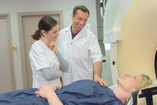 Medical workers reassuring patient entering mri scanner