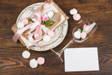 Light pink roses and tableware on the wooden table