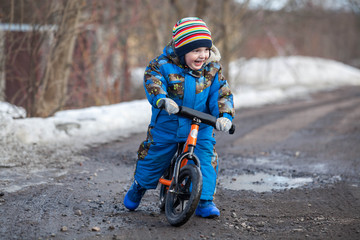 Child in ride balance bike (run bike) at winter