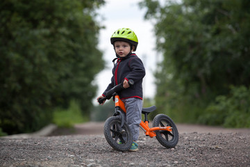 Child in helmet ride balance bike (run bike)