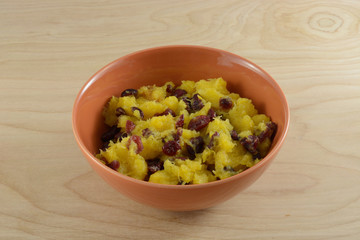 Acorn squash and dried cranberries in orange bowl