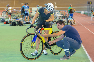 Cyclist and instructor looking at bicycle