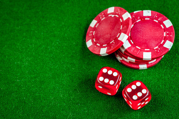 poker chips and dice on green background top view