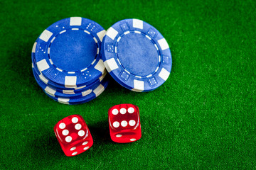 poker chips and dice on green background top view