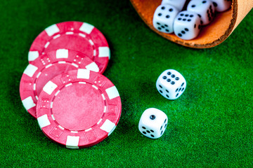poker chips and dice on green background top view