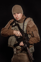 Fototapeta premium Portrait soldier or private military contractor holding rifle.