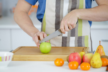 Apple being cut in half on chopping board