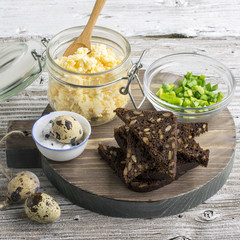 Egg salad cheese spread made toast and open sandwiches for a snack with green onions  bread roll. On  round cutting board supply. selective focus