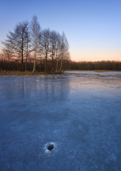Sunset in the cold evening on the frozen lake.