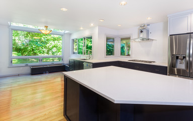 Kitchen looks more functional with a sink, cooktop, refrigerator and partially installed vent hood. Window seat bench bases installed