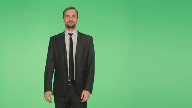 man in a suit on a green background. body language. fright. hromakey