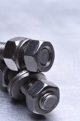 Steel Nuts and Bolts on Metal Background