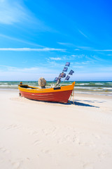 Fototapeta na wymiar Colorful fishing boat on sandy Debki beach, Baltic Sea, Poland