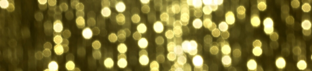 Glitter sparkling abstract gold bokeh defocused background, border design panoramic banner 
