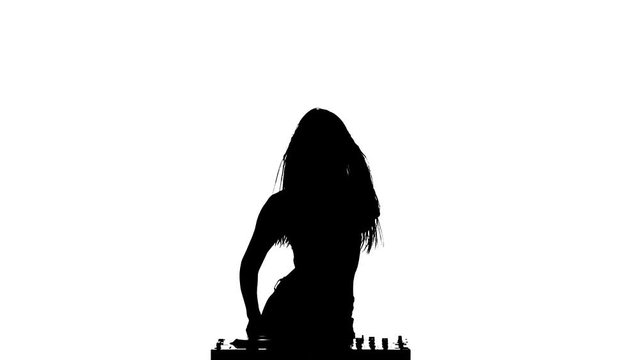 Girl DJ spins his sexy body and turns the turntable. Slow motion. Silhouette