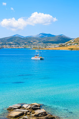 Catamaran boat saiing on azure sea in Monastiri bay on Paros island, Greece