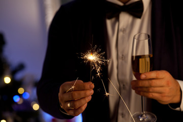 Hands of man holding Bengal light at the party.