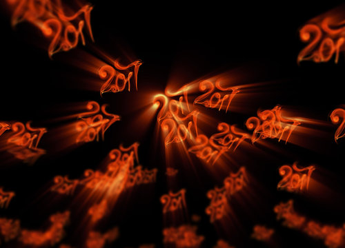Happy new year 2017 flying digits numbers written with fire flame light on black background