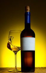 Bottle of wine with glass, with splash liquid