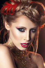 Fototapeta premium portrait of a beautiful girl with bright make-up with gold glitter