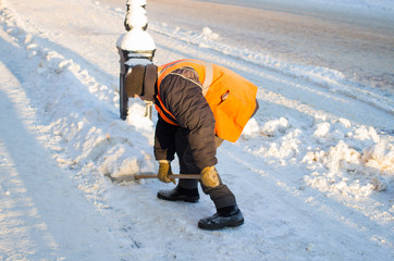 Janitor cleans the street of snow