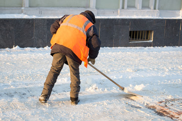 Janitor cleans the street of snow