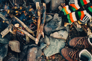Boots and socks drying near campfire