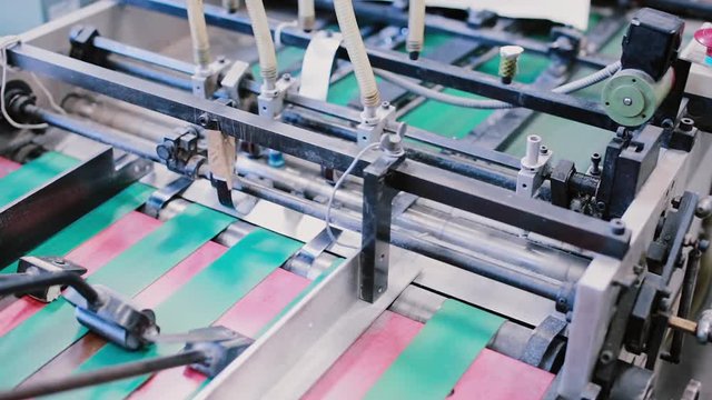 Newspapers in the process of publishing with sound. Printing establishment detail on production line with sound.