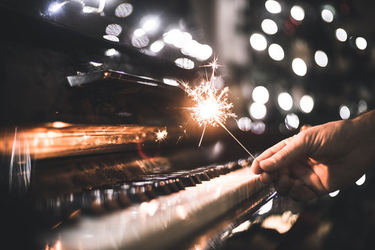 hand holding a sparkler over a piano