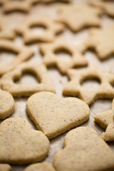 Homemade baked heart and star shaped biscuits on the baking pape