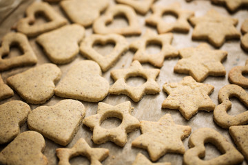 Homemade baked heart and star shaped biscuits on the baking pape