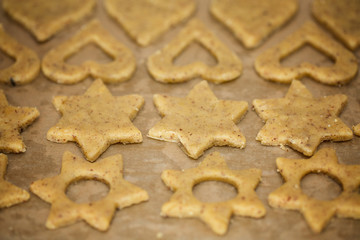 Fototapeta na wymiar Raw homemade baked heart and star shaped biscuits on the baking