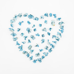 Heart symbol made of dry flowers on white background. Hydrangea. Flat lay. Top view