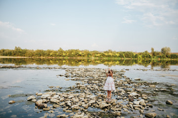 girl holding a dry stone of the river