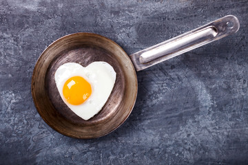 Fried egg in heart shape on the pan.Holiday Valentine's Day.Breakfast. Healthy Food.selective focus.
