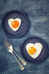 Fried egg in heart shape on the pan.Holiday Valentine's Day.Breakfast. Healthy Food.Toned image.Vintage style.selective focus.