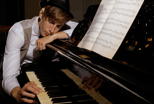 Young musician posing near piano